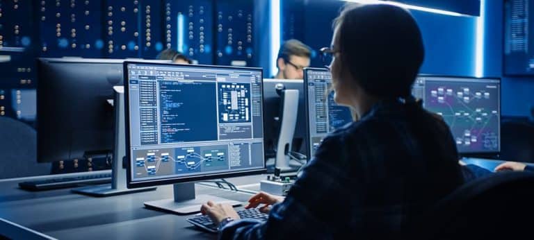 Smart Female IT Programer Working on Desktop Computer in Data Center System Control Room